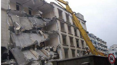 台中房屋拆除現場，大型機具正在進行建築物主體拆除作業，揚塵控制得當，確保周邊環境不受影響。